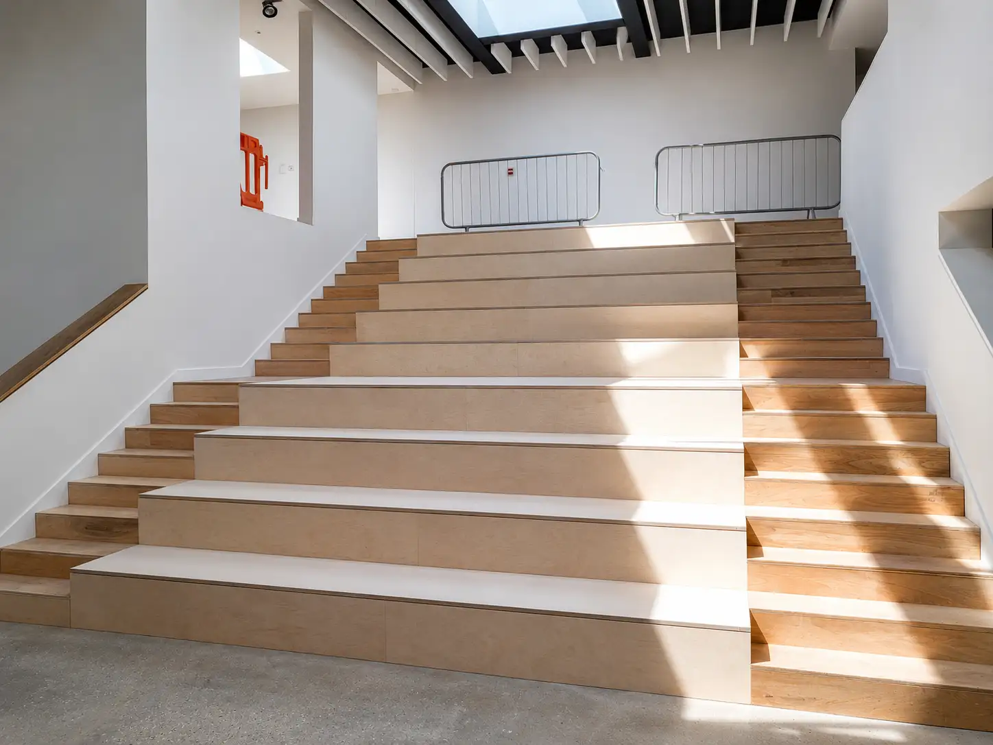 Wide oak-faced stepped seating and stair feature in a commercial interior fit-out