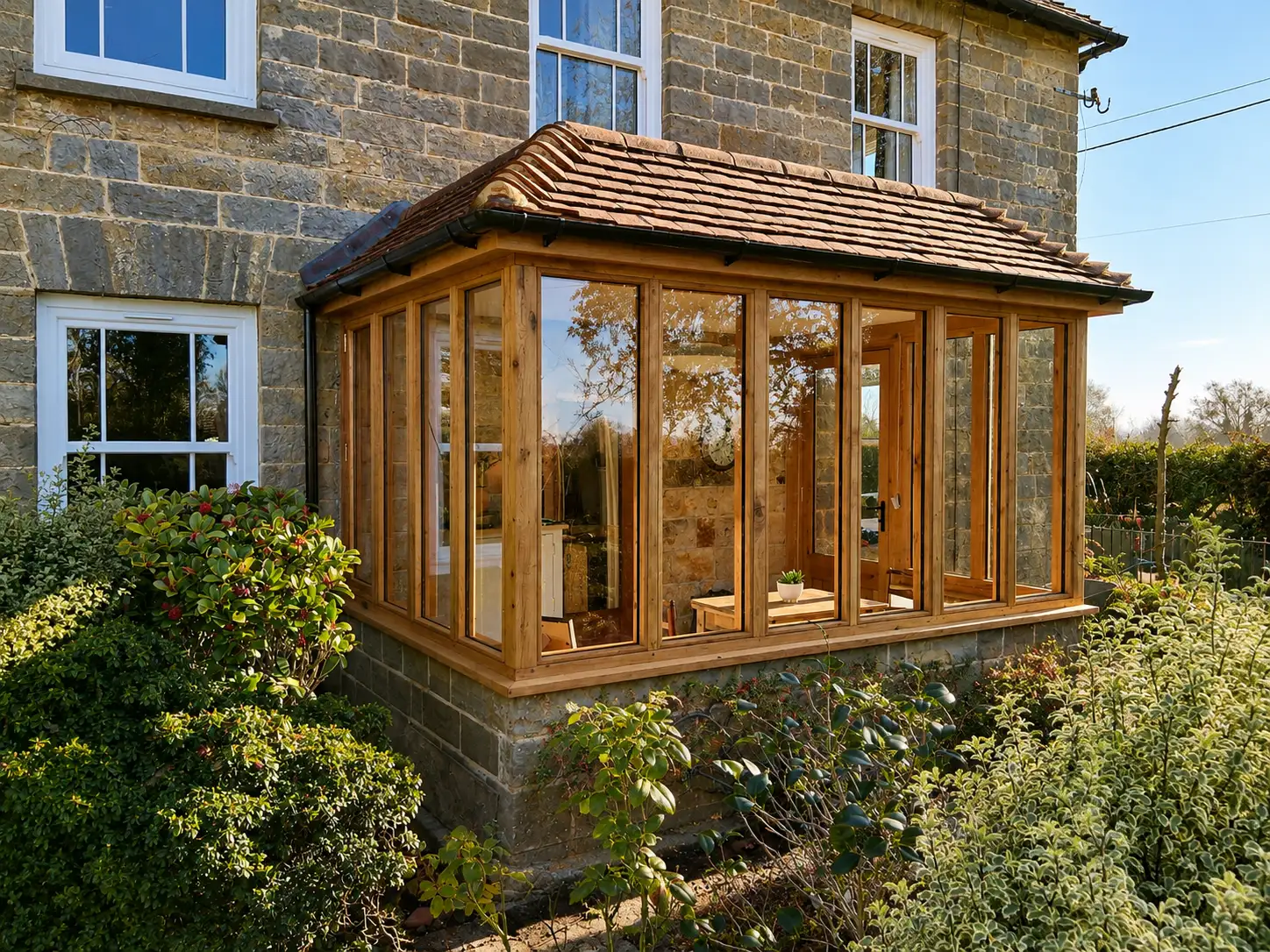 Hand-built oak garden room with full-height glazing on a Sussex stone cottage