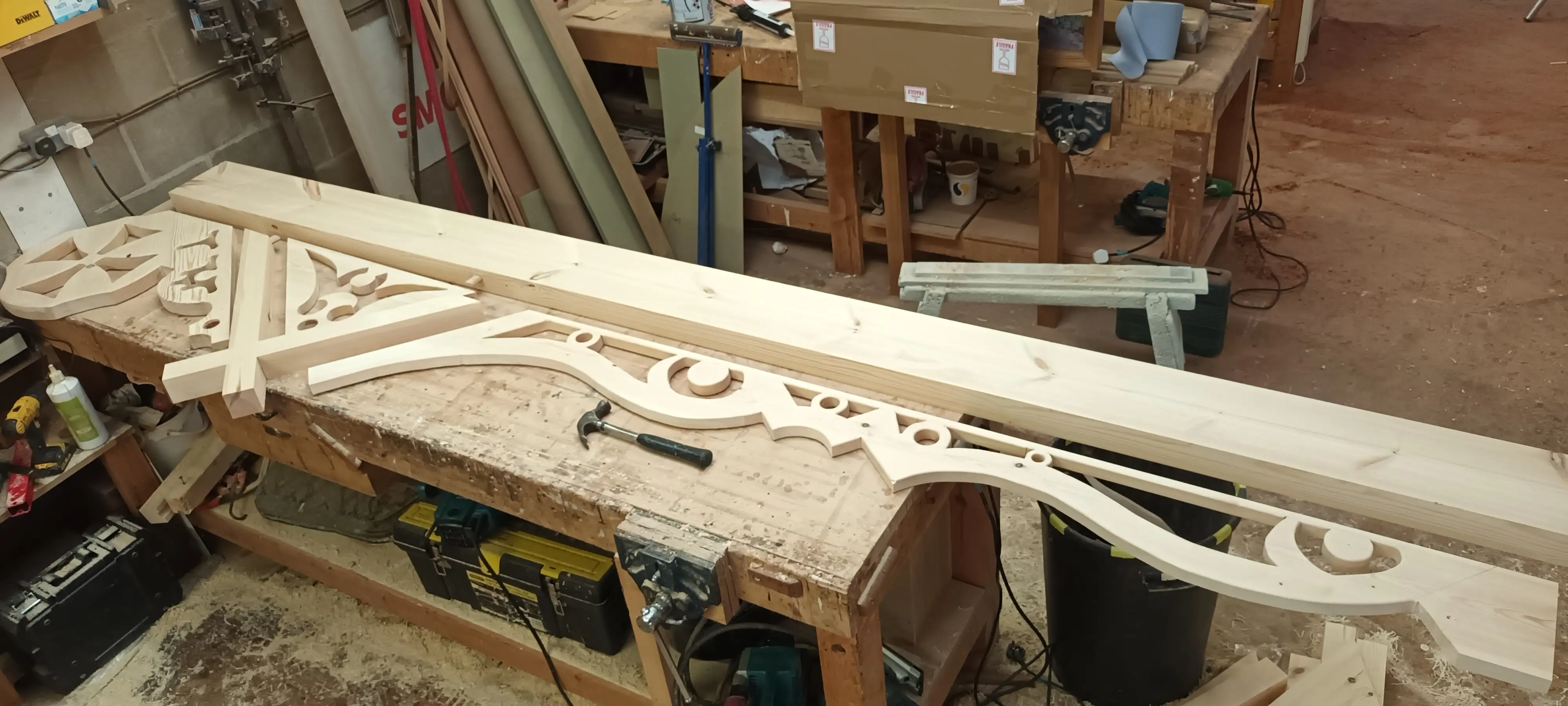 Hand-carved Gothic and Victorian fretwork architectural pieces on a workshop bench