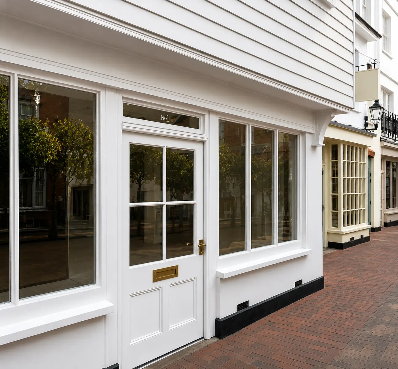Hand-built white painted period shopfront with small-pane glazing and panelled door on a Sussex high street