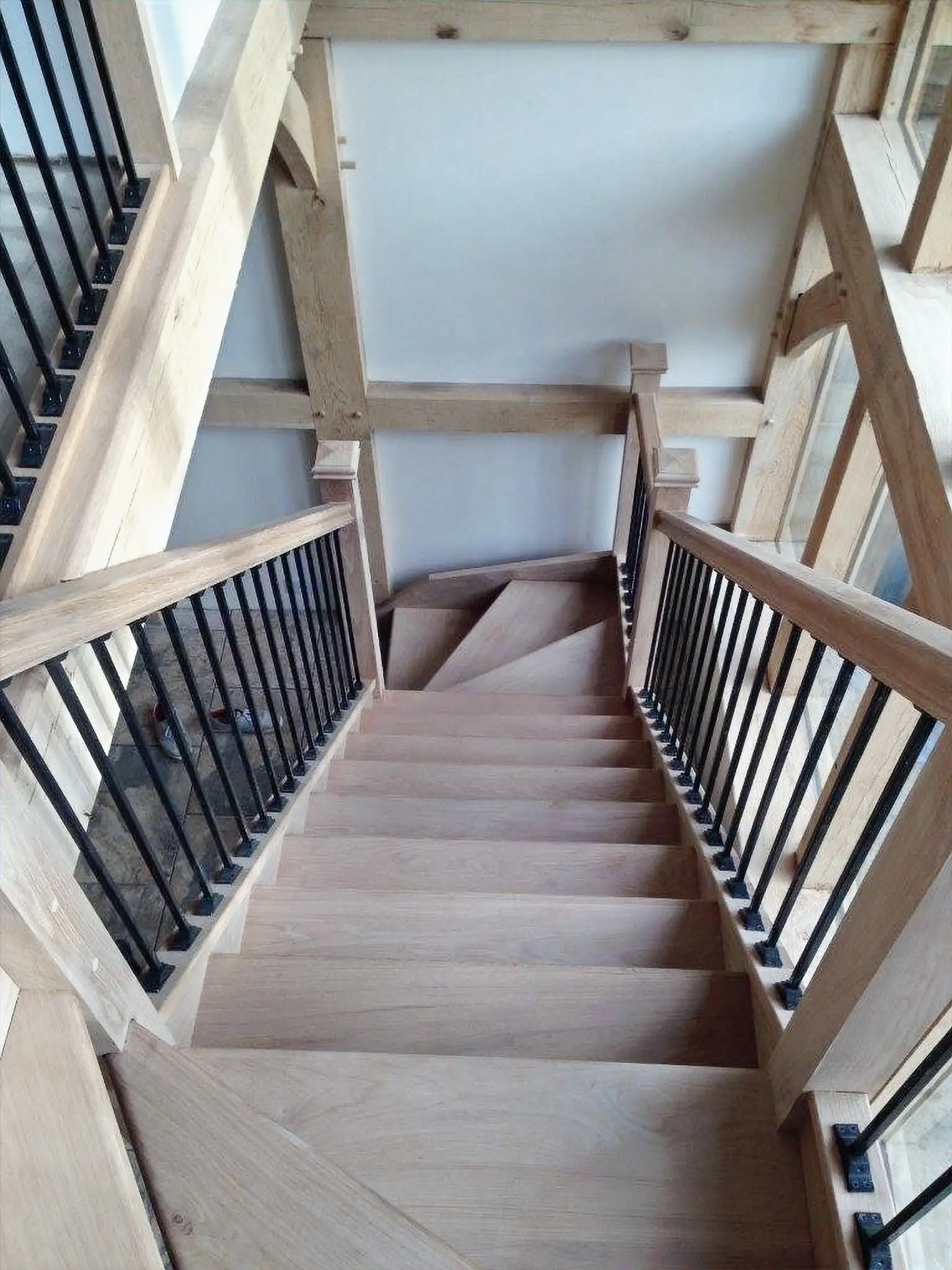 Modern oak staircase with black metal spindles, view looking down