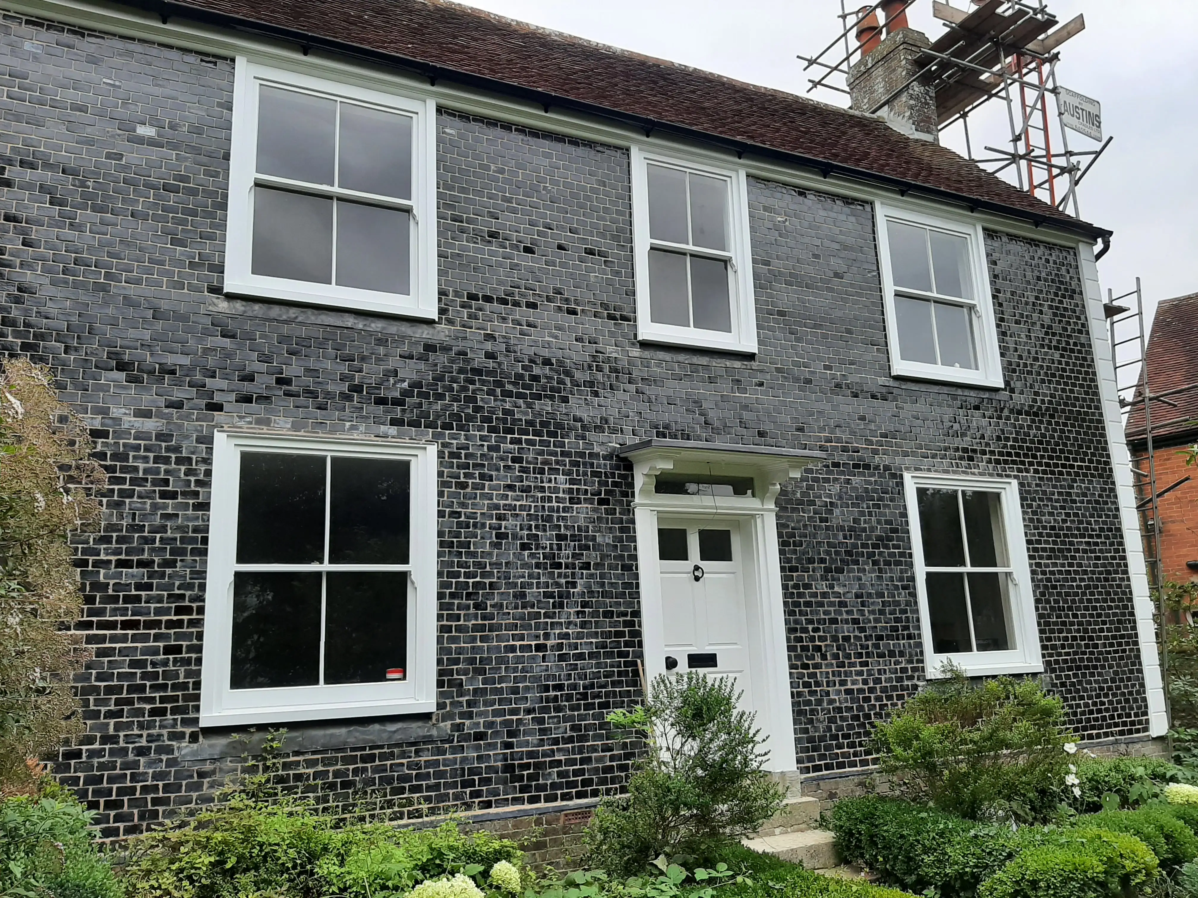 White sash windows on a Sussex listed cottage in mathematical tile