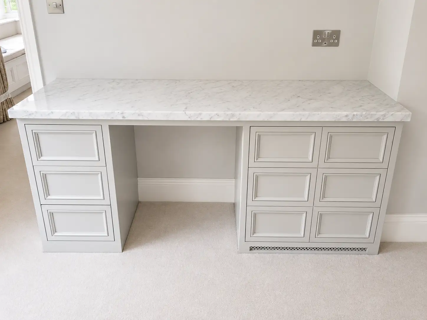 Built-in panelled dressing table with a Carrara marble top and twin drawer pedestals
